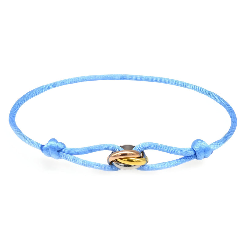 Bracelet cordon bleu clair avec petit pendentif cercles entrelacés en métal doré et argenté.