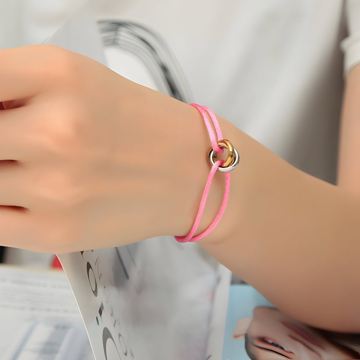 Bracelet cordon rose avec cercles entrelacés dorés élégant pour femme.