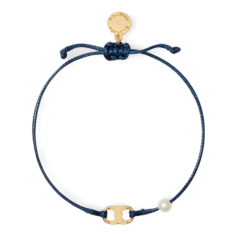 Bracelet cordon bleu marine fin avec perle blanche et médaille dorée gravée.