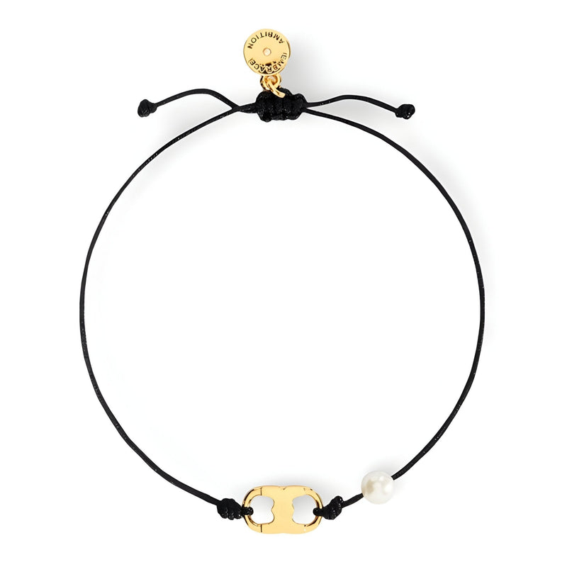 Bracelet cordon noir minimaliste avec perle blanche et pendentif doré délicat.