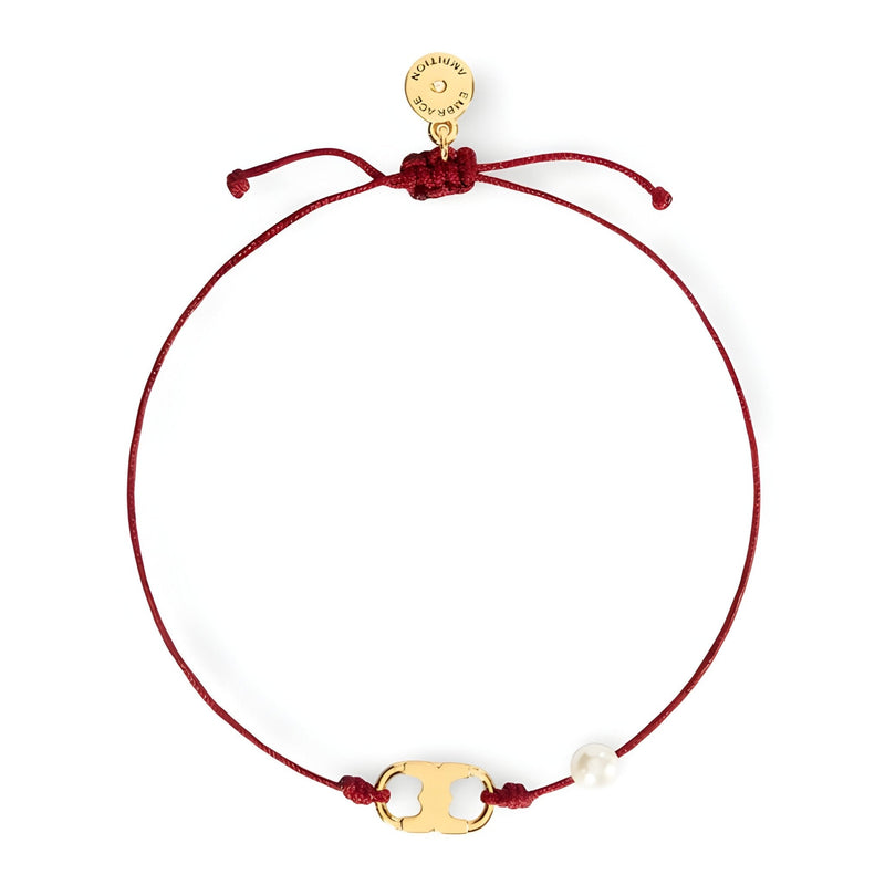 Bracelet cordon rouge avec perle blanche et petit médaillon doré minimaliste.