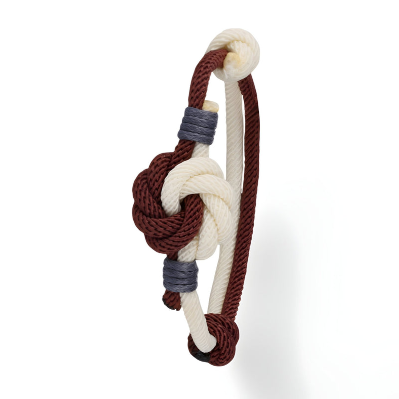 Bracelet cordon bicolore rouge et blanc avec noeud central et détails gris en corde tressée.