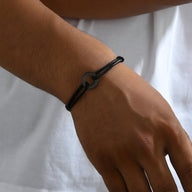 Bracelet cordon noir pour homme avec charm arrondi mat élégamment tressé.