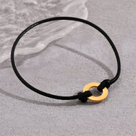 Bracelet cordon noir avec charm arrondi en métal doré ajustable pour homme.