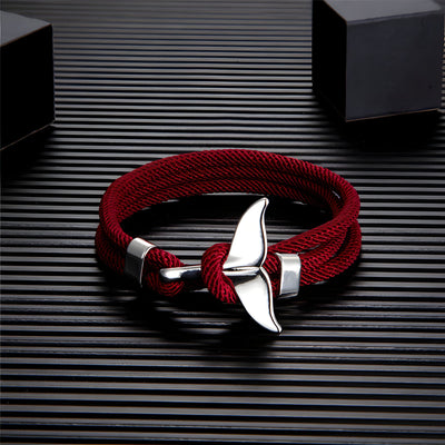 Bracelet cordon bordeaux pour homme avec pendentif queue de baleine argentée et détails métalliques.