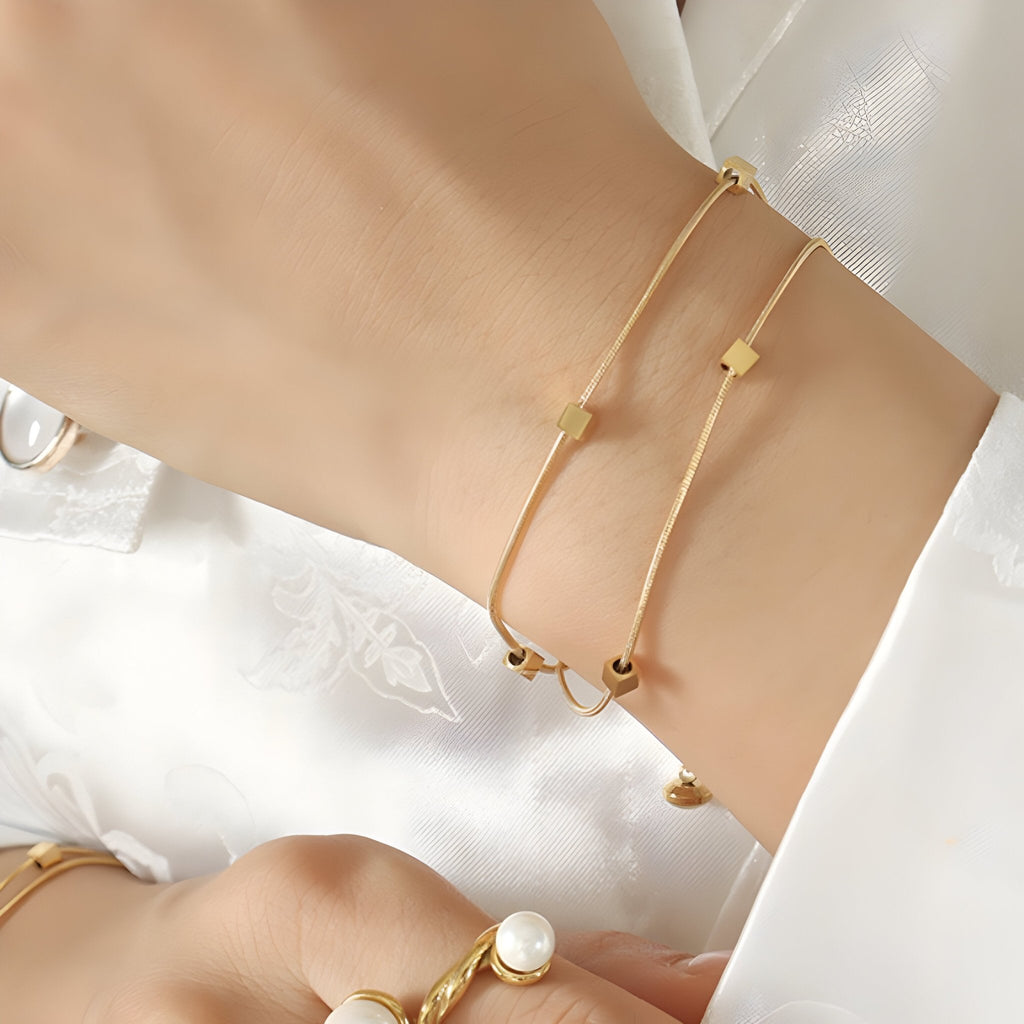Bracelet double en titane plaqué or avec motif de petits cubes minimalistes, élégant et fin.