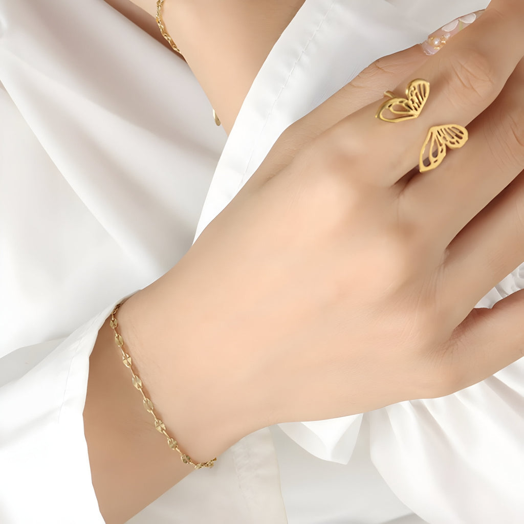 Bracelet fin en titane plaqué or avec maillons délicats porté sur poignet féminin.