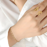 Bracelet fin en titane plaqué or avec maillons délicats porté sur poignet féminin.