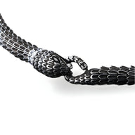Bracelet serpent en acier inoxydable noir avec détail texturé écailles et fermoir anneau circulaire.