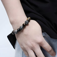 Bracelet homme en acier inoxydable et perles œil de tigre marron avec médaillon décoratif argenté.