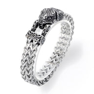 Bracelet en acier inoxydable argenté avec fermoir tête de serpent sculptée et maillons tressés détaillés.