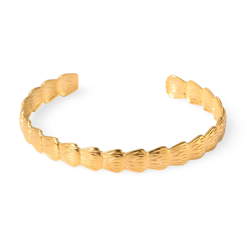 Bracelet jonc ouvert en acier inoxydable plaqué or avec motif hexagonal texturé.