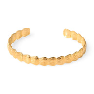 Bracelet jonc ouvert en acier inoxydable plaqué or avec motif hexagonal texturé.