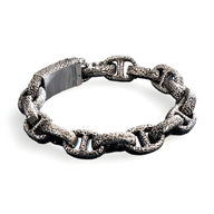 Bracelet masculin en acier inoxydable argenté avec maillons texturés aspect rocheux et fermoir large.