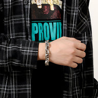 Bracelet homme en acier inoxydable argenté à maillons larges, style rocheux, porté au poignet.