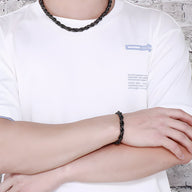 Bracelet torsadé en acier inoxydable noir pour homme porté au poignet.