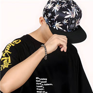 Bracelet noir en acier inoxydable pour homme avec charme haltère, style élégant et masculin.