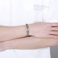 Bracelet homme en acier inoxydable argenté avec double tête de serpent et maillons texturés.