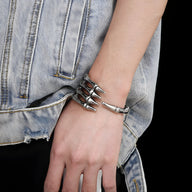 Bracelet en acier inoxydable argenté en forme de main de squelette, style masculin, porté au poignet.