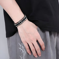 Bracelet homme en acier inoxydable noir avec incrustations de fils de fer, style industriel.