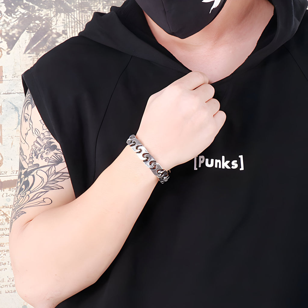 Bracelet homme maille gourmette en acier inoxydable argent porté au poignet, style urbain.