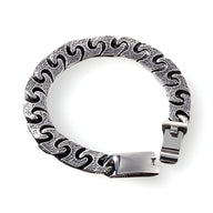 Bracelet homme en acier inoxydable argenté à maille gourmette avec motif ondulé noir et fermoir plaque lisse.
