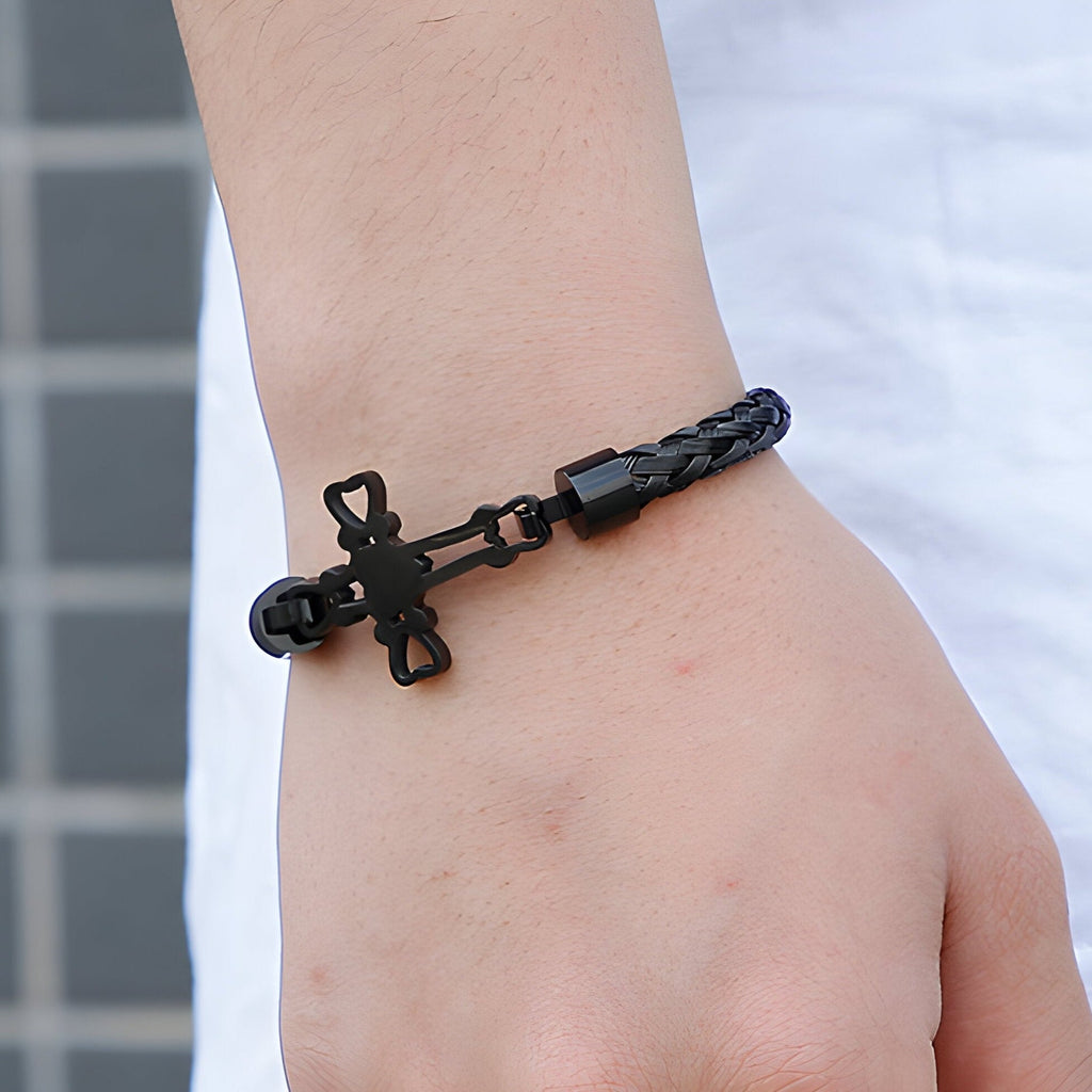 Bracelet homme noir en acier inoxydable avec motif croix et chaîne tressée.