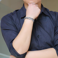 Bracelet homme en acier inoxydable argenté, motif floral, maillons larges et brillants.