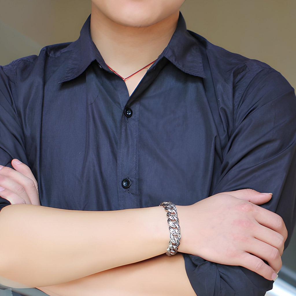 Bracelet homme en acier inoxydable argenté avec motif floral, porté sur poignet masculin.