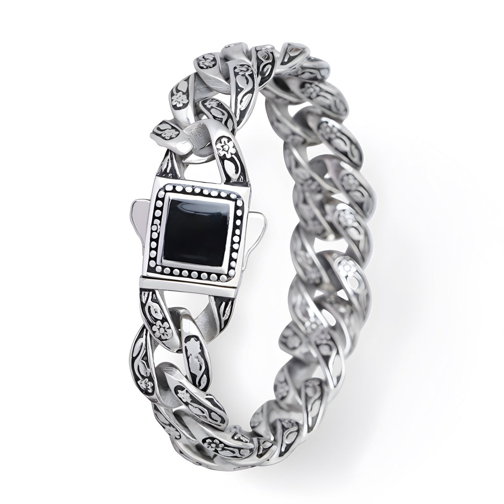 Bracelet homme en acier inoxydable argenté avec motif floral et pierre noire carrée centrale.