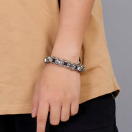 Bracelet homme en acier inoxydable argenté avec motifs celtiques en relief, style maillons robustes.