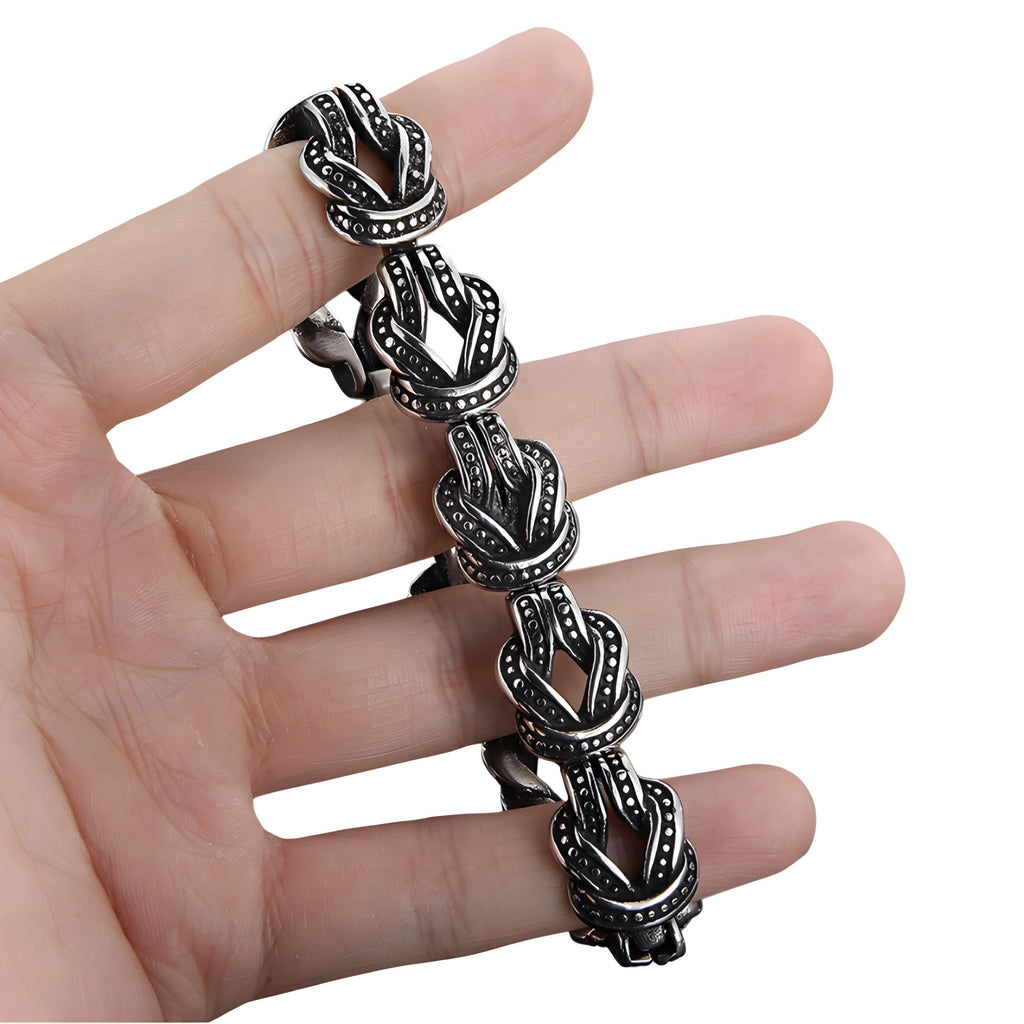 Bracelet homme en acier inoxydable argenté avec motifs de nœuds celtiques noirs gravés.