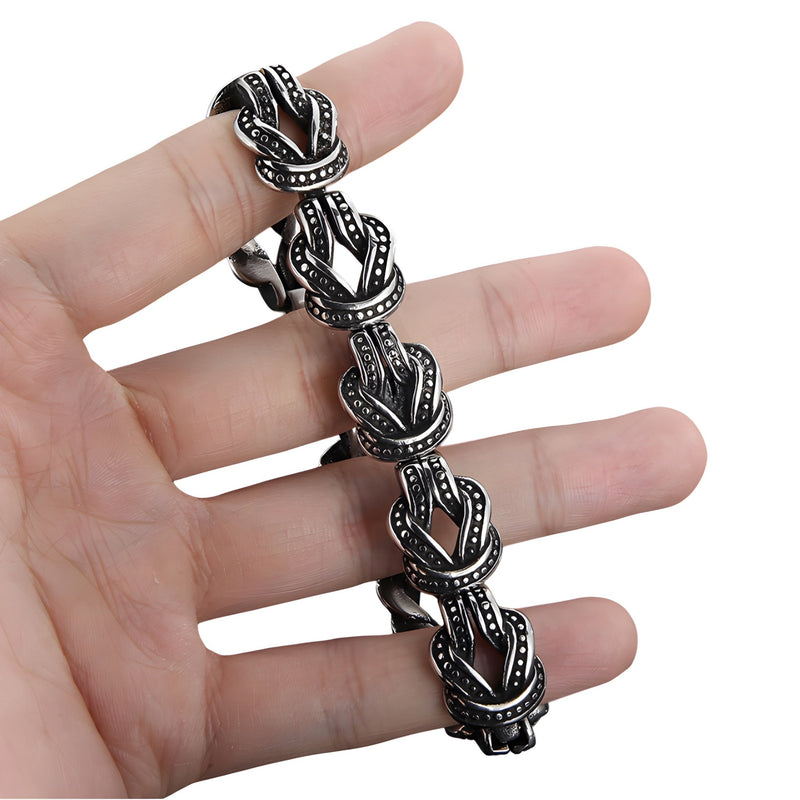 Bracelet homme en acier inoxydable argenté avec motifs de nœuds celtiques noirs gravés.
