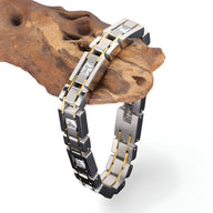 Bracelet homme en acier inoxydable argent avec maillons rectangulaires et détails dorés, serti de petits strass scintillants.
