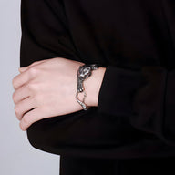 Bracelet argenté en acier inoxydable pour homme avec motif tigre s'accrochant en relief.