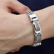 Bracelet en acier inoxydable argenté avec maillons larges et strass brillant sur le fermoir.
