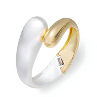 Bracelet manchette en alliage plaqué or et argent, design ouvert avec ressort visible.