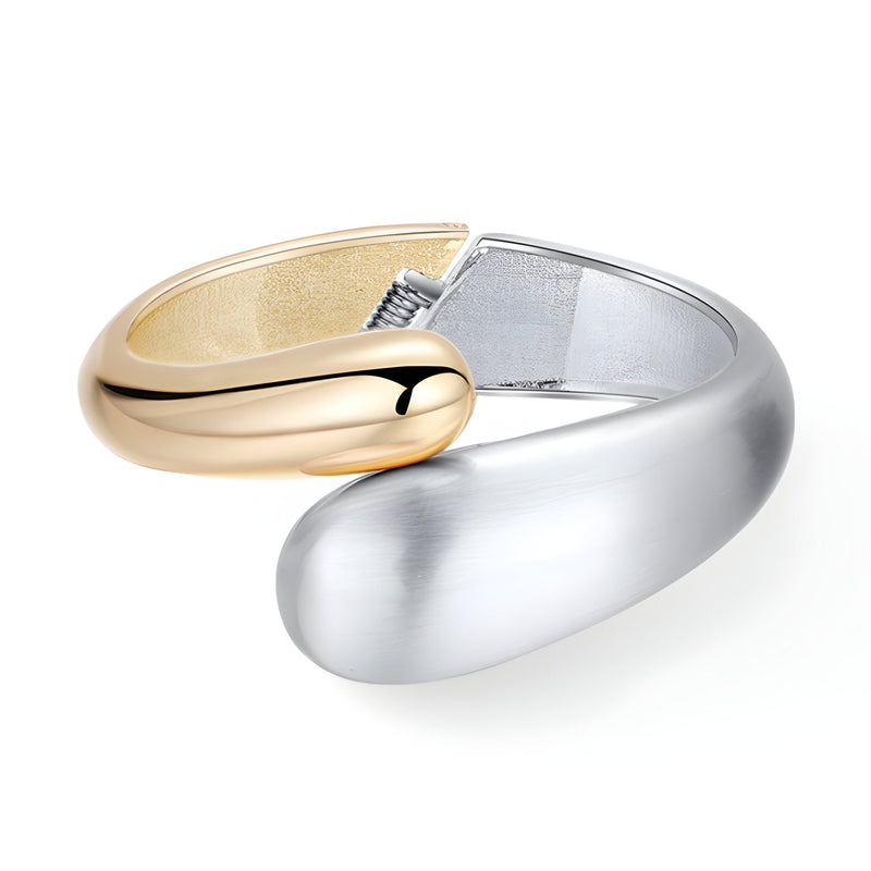 Bracelet manchette ouvert bicolore en alliage plaqué or et argent au design épuré et incurvé.