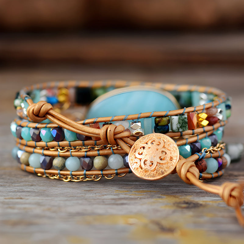 Bracelet multi-rangs en pierres d'amazonite bleu clair avec perles multicolores et bouton doré gravé sur cuir marron.