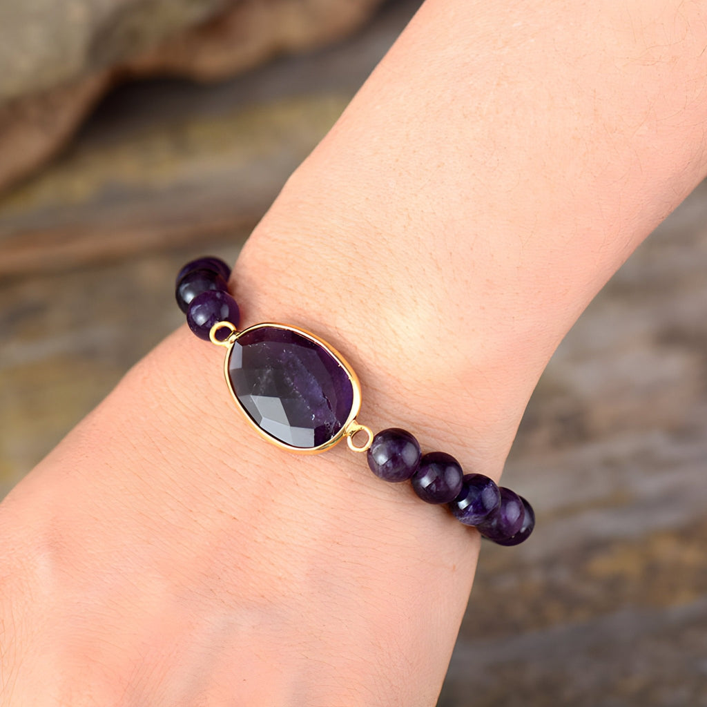 Bracelet femme perles améthyste violettes avec pierre facettée ovale sertie or.