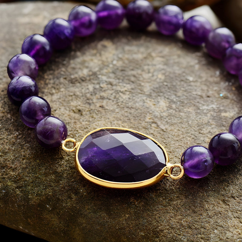 Bracelet violet en perles d'améthyste avec pendentif ovale facetté serti or.