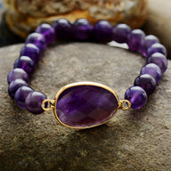 Bracelet violet en améthyste avec pierre centrale ovale facettée sertie or, perles rondes lisses.