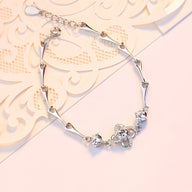 Bracelet femme en argent massif avec charms en forme de trèfle et détails raffinés.