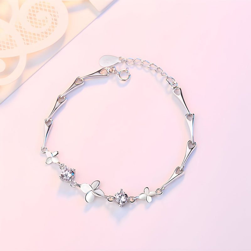 Bracelet en argent massif avec pendentifs trèfle à quatre feuilles et petites fleurs délicates.