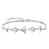 Bracelet en argent massif avec pendentifs trèfle à quatre feuilles et pierres brillantes, fermoir réglable.