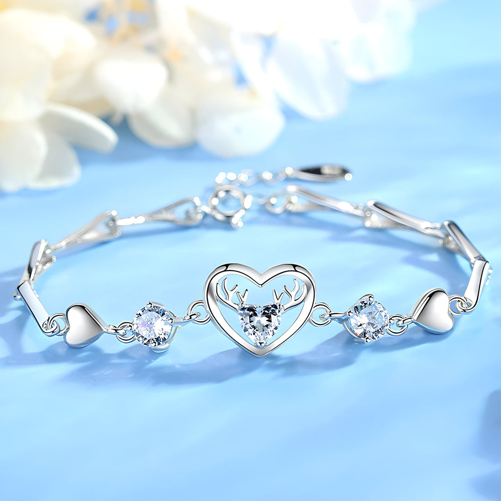 Bracelet en argent avec charms cœur et cerf central, orné de pierres blanches brillantes.