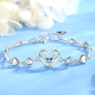 Bracelet en argent avec charms cœur et cerf central, orné de pierres blanches brillantes.
