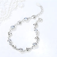 Bracelet argent avec maillons en forme de cœur et pierres brillantes rondes.