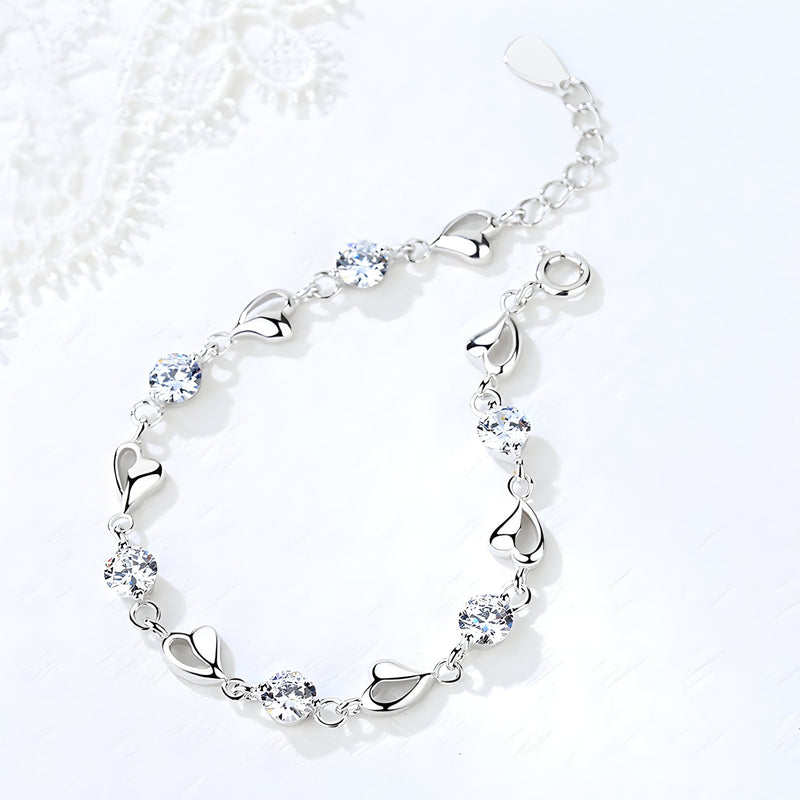 Bracelet argent avec maillons en forme de cœur et pierres brillantes rondes.