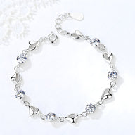 Bracelet en argent pur pour femme avec maillons en forme de cœur et pierres bleues brillantes.